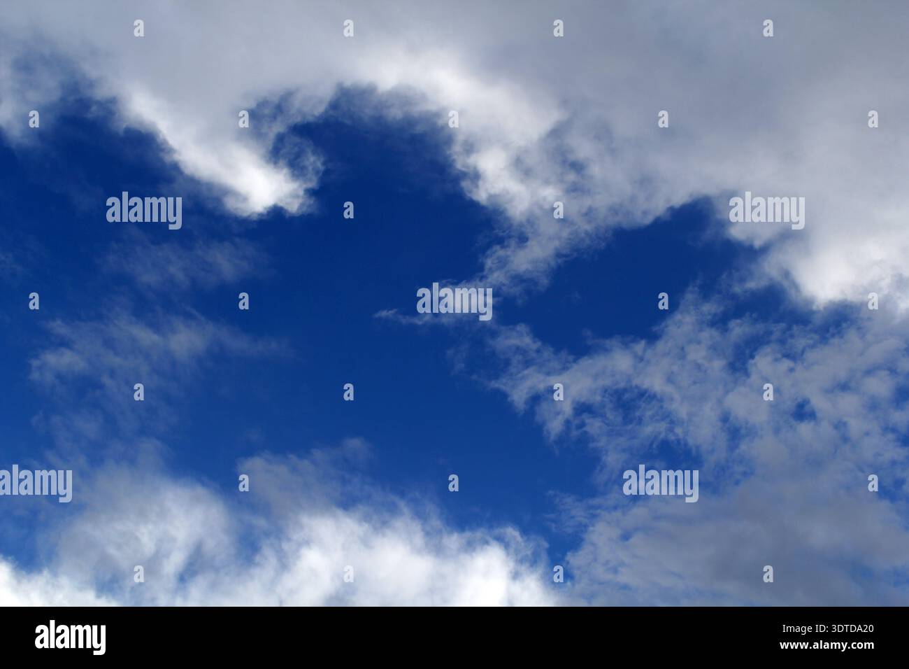 Blue sky with scattered white clouds abstract background Stock Photo