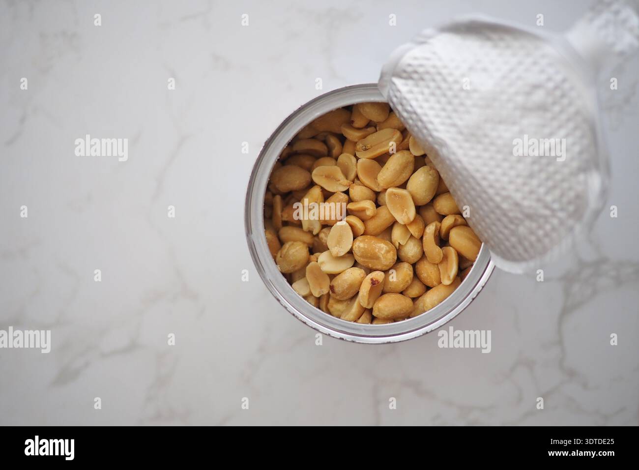 Peanuts in a can on a marble surface Stock Photo