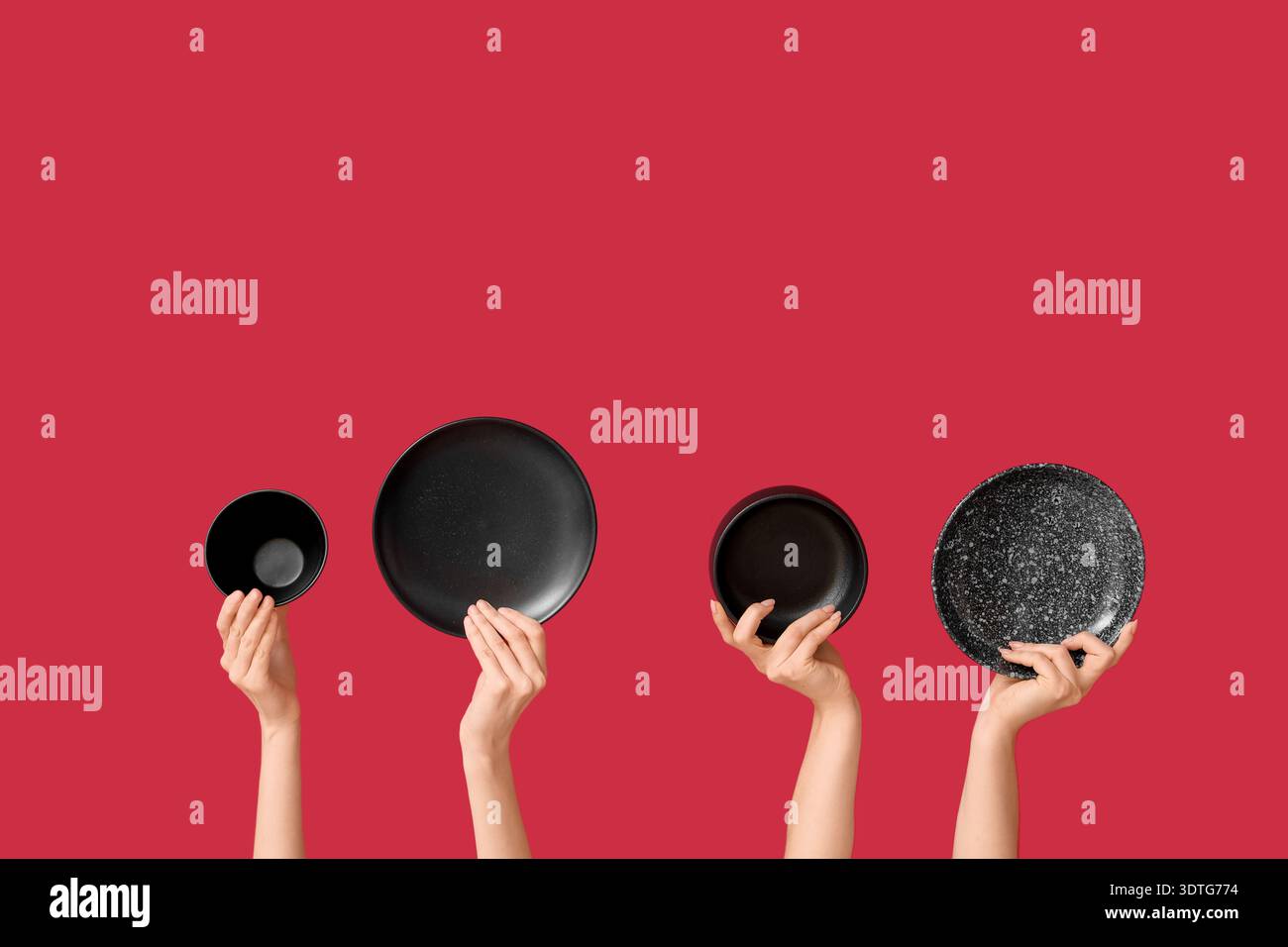Hands holding empty plates on red background Stock Photo