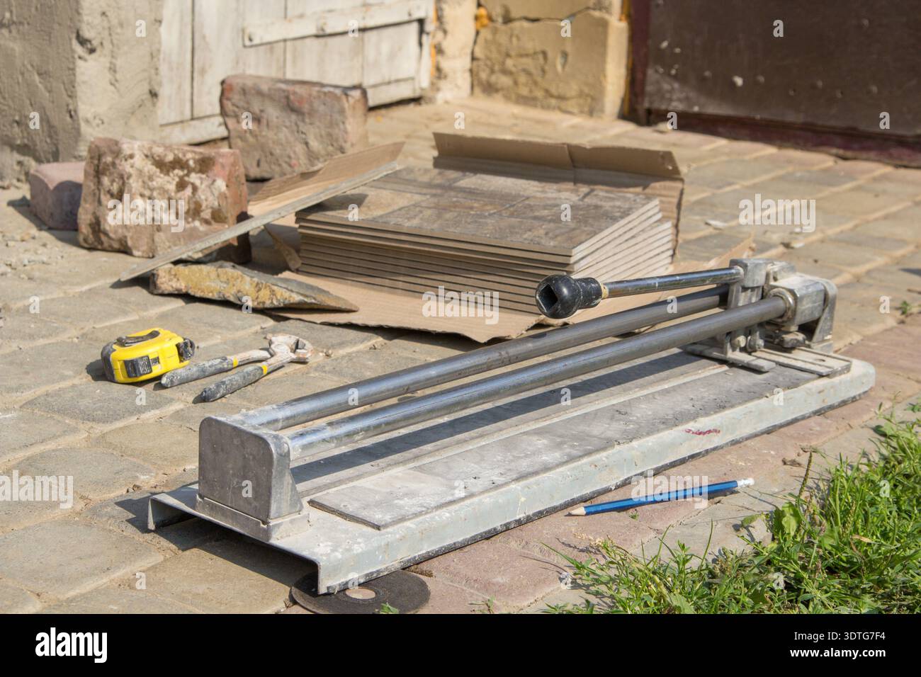 hand tool tile cutter with a bundle of ceramic tile at work, tile tools Stock Photo
