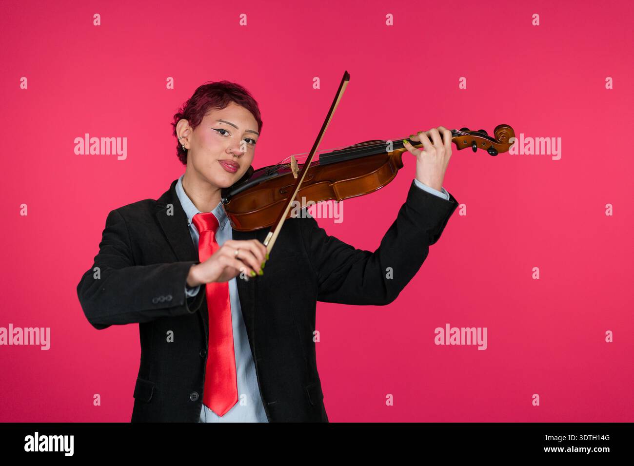 Young musician playing violin wearing tie and jacket Stock Photo