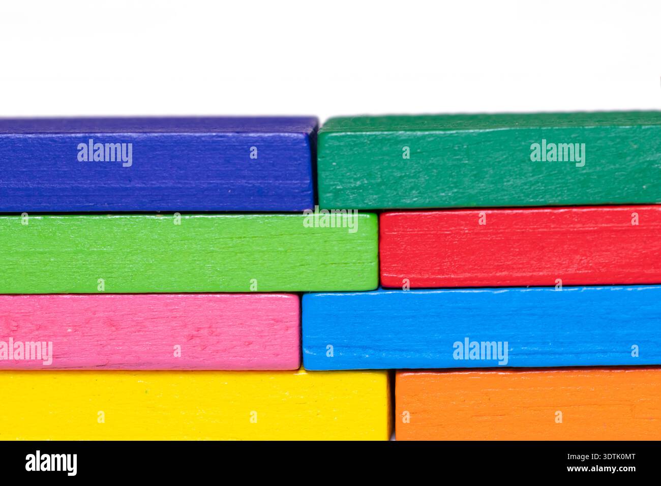 Wooden blocks in rainbow colors stacked together, forming a solid row ...