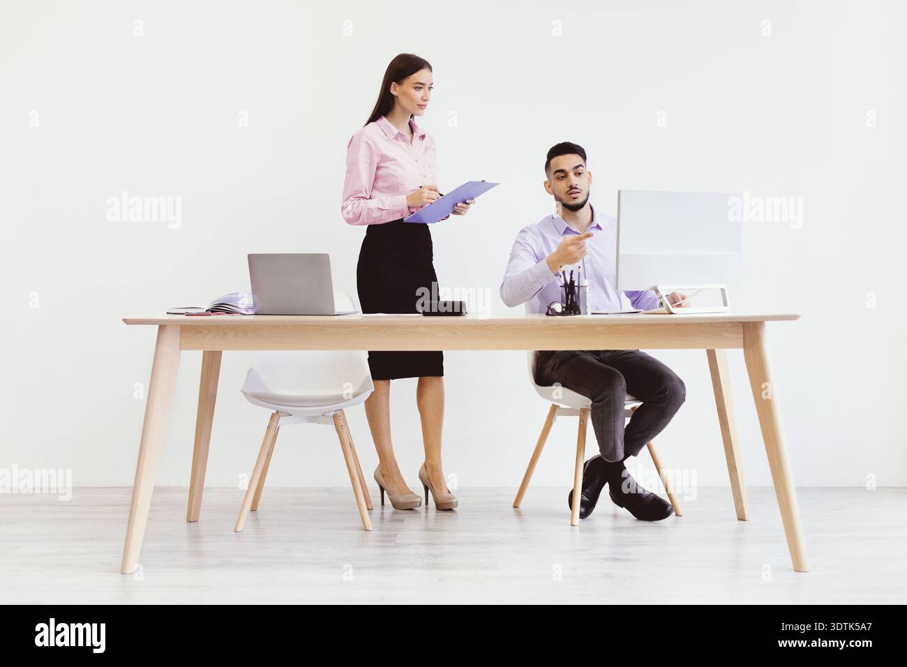 Discussion Between Two Professionals in a Modern Office Setting Stock Photo