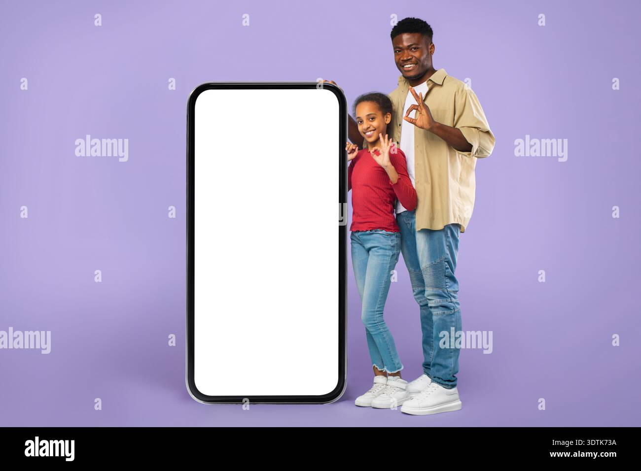 Two People Standing Next to a Large Blank Screen in a Studio Setting at a Fun Event Stock Photo
