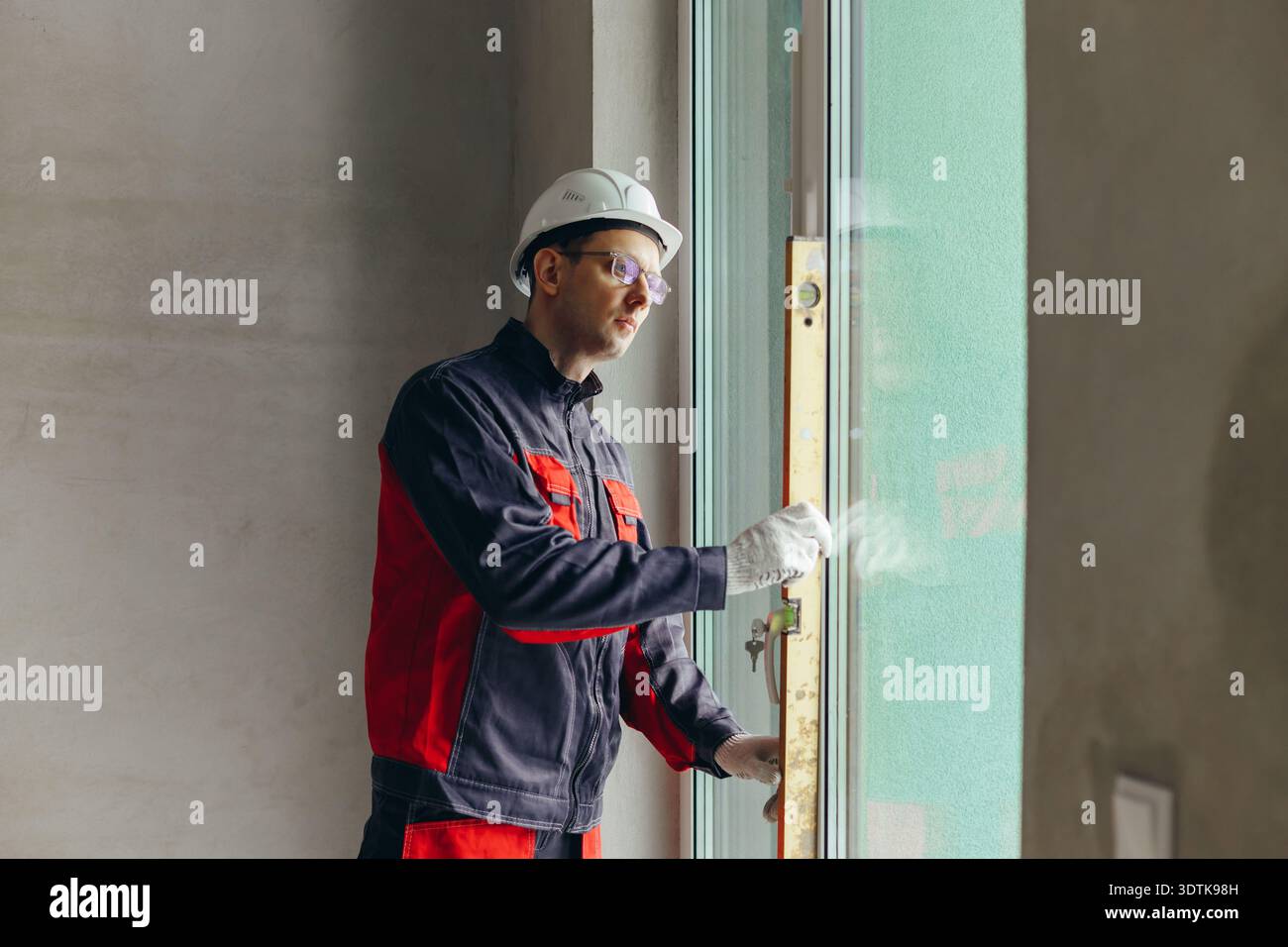 Window Frame Alignment Technician Using Spirit Level To Check Vertical Alignment Of Window ...
