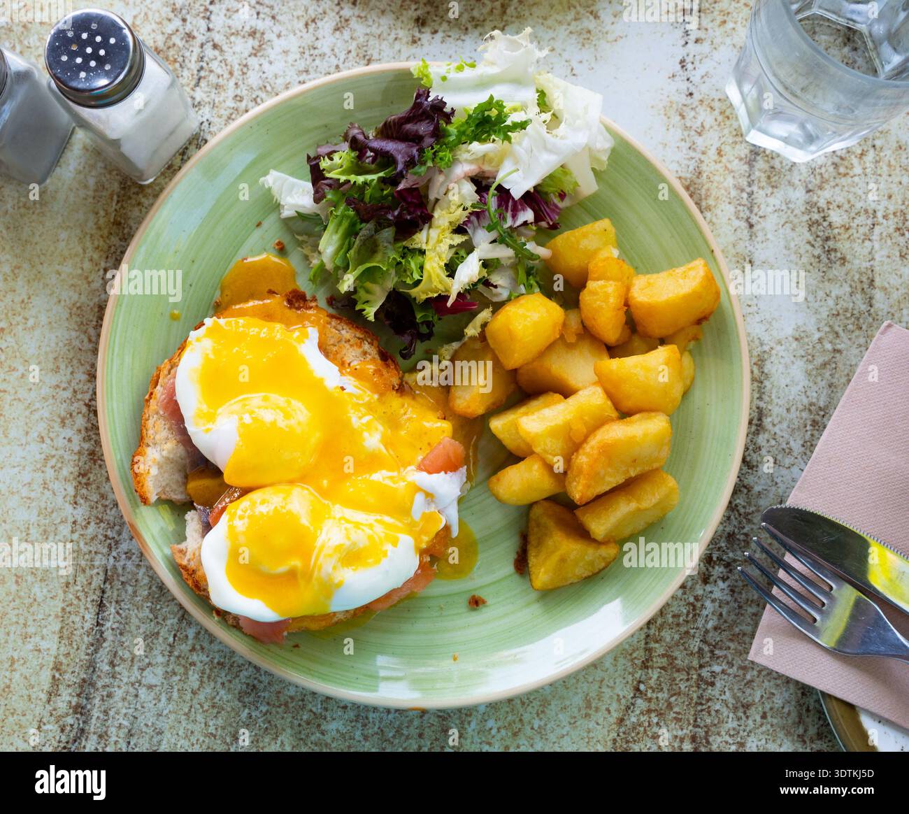 Portion of eggs benedict toast with salmon and potatoes closeup Stock Photo