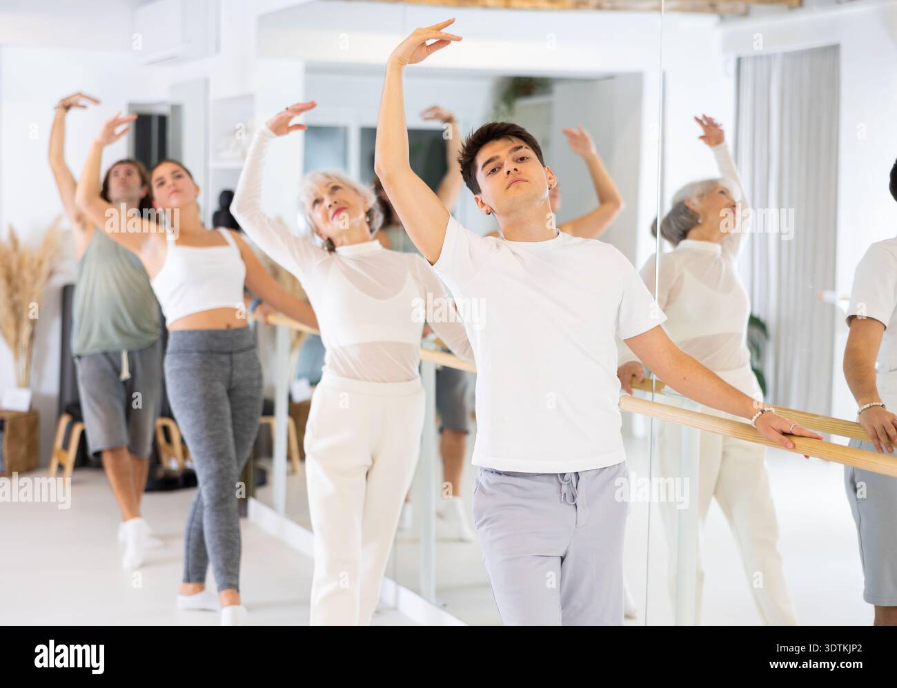 Diligent young man doing choreography at ballet barre Stock Photo