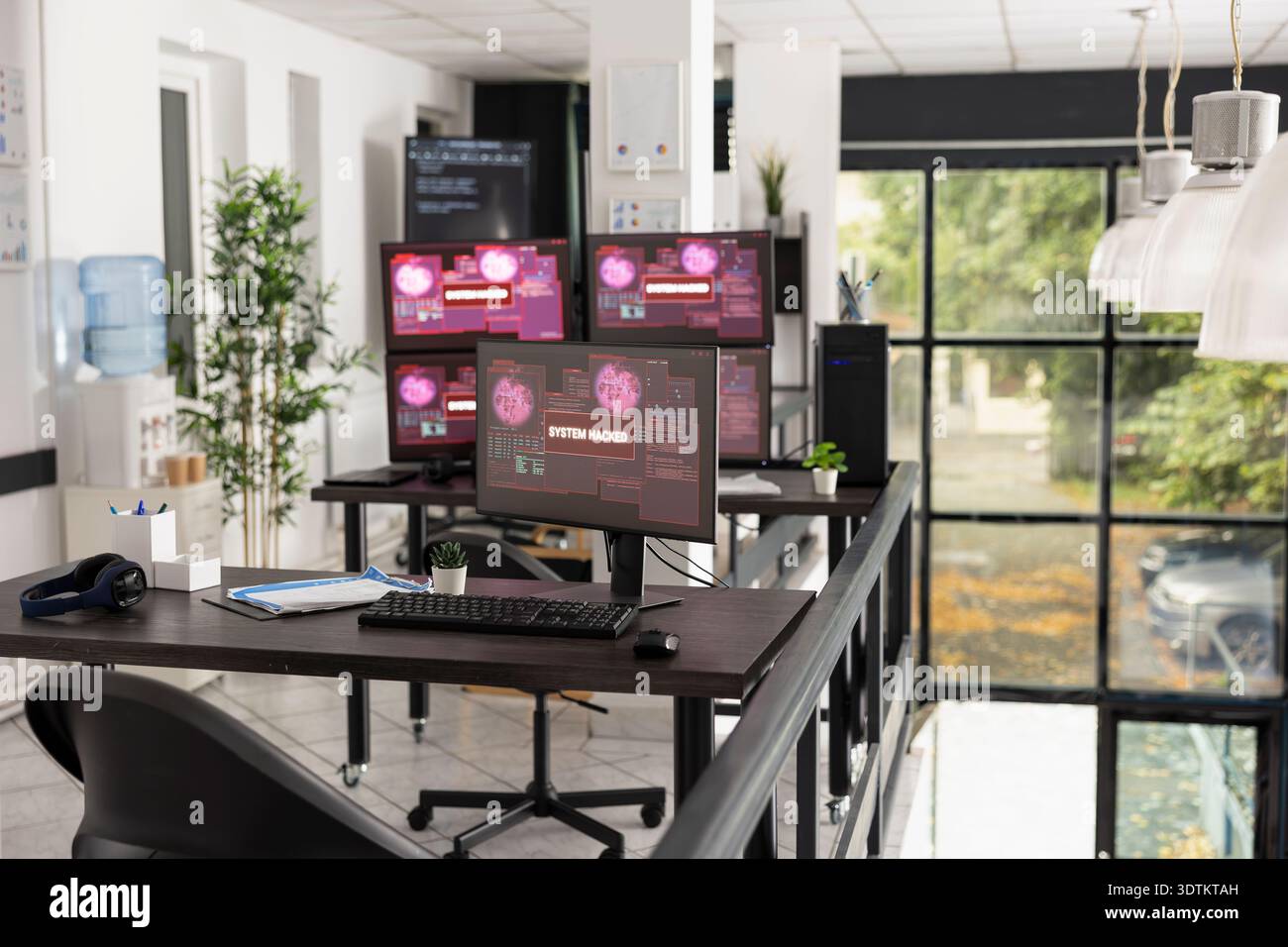 Desktop monitors show system error warnings in empty office workspace. The scene represents software failure, technical issues and business interruption in modern IT environment. Stock Photo