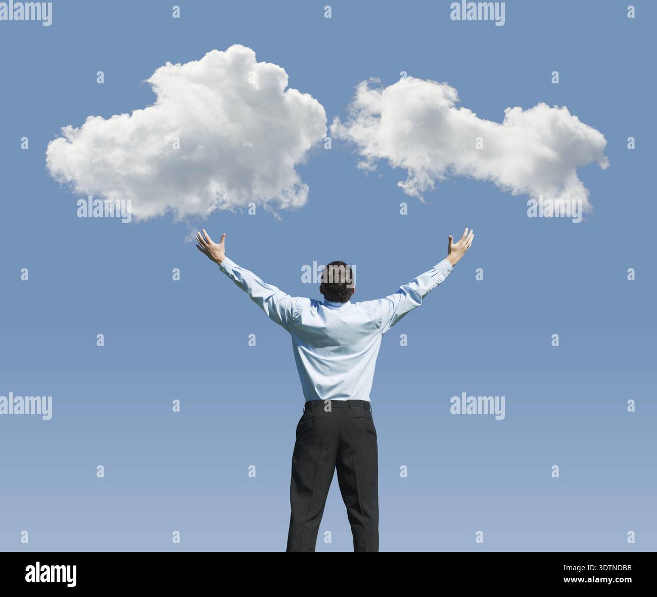 Beautiful clouds and happy young man with his hands up.Concept image on cloud computing and rest Stock Photo