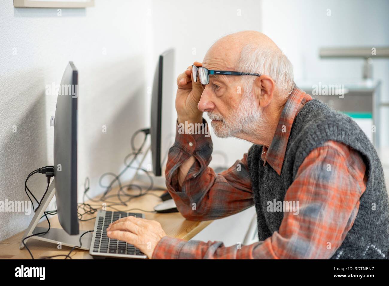 Senior man working on computer at desk. Stock Photo