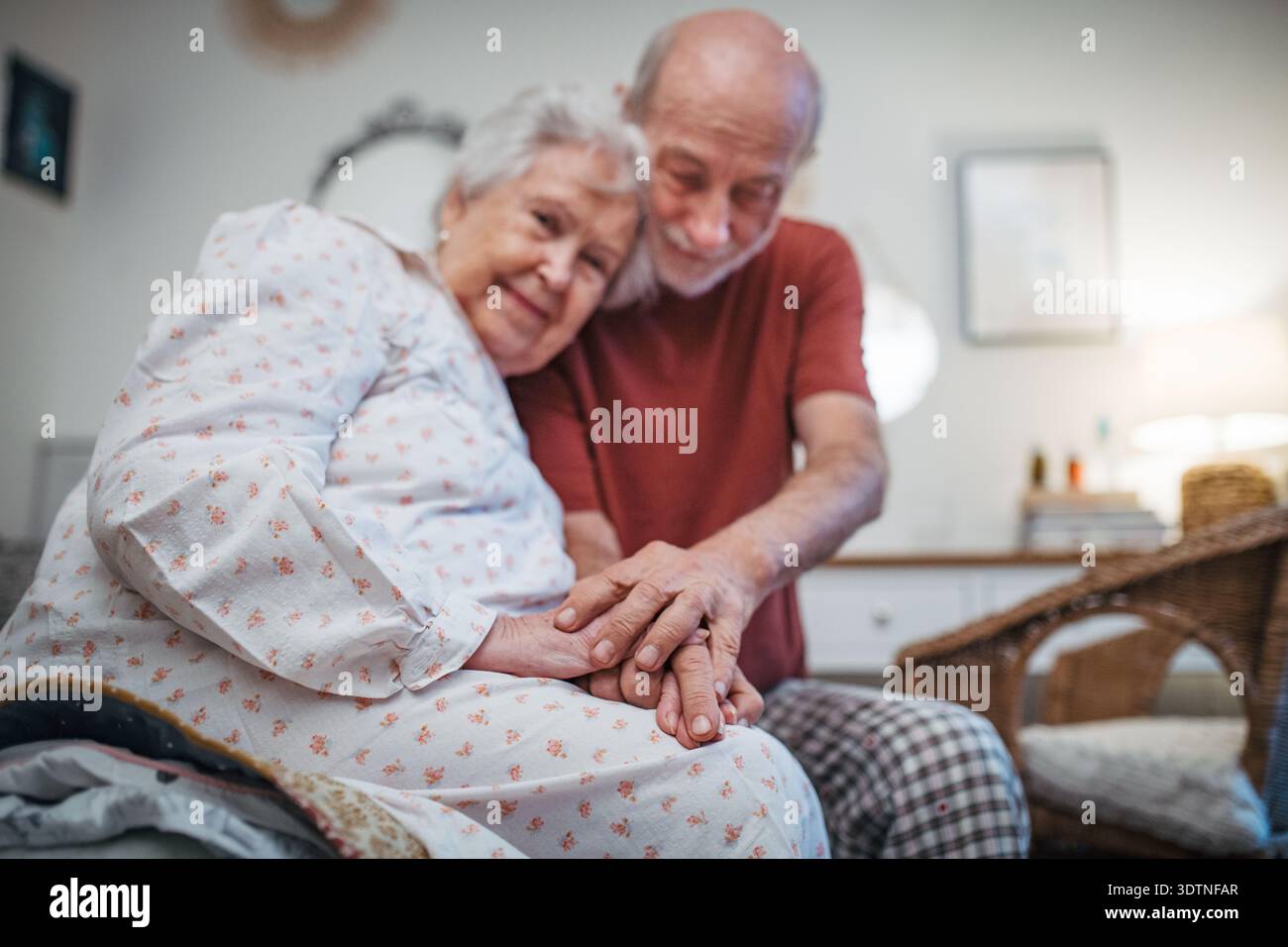 Elderly spouses sharing quiet moment before sleep. Stock Photo