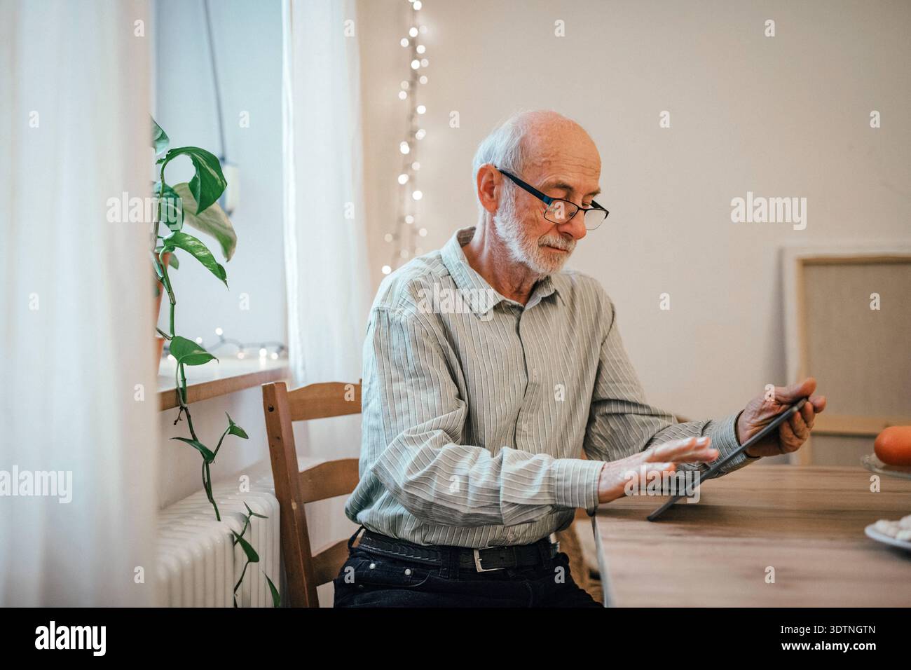 Elderly man using tablet, shopping online. Elderly man using digital tablet, shopping online. model released Stock Photo