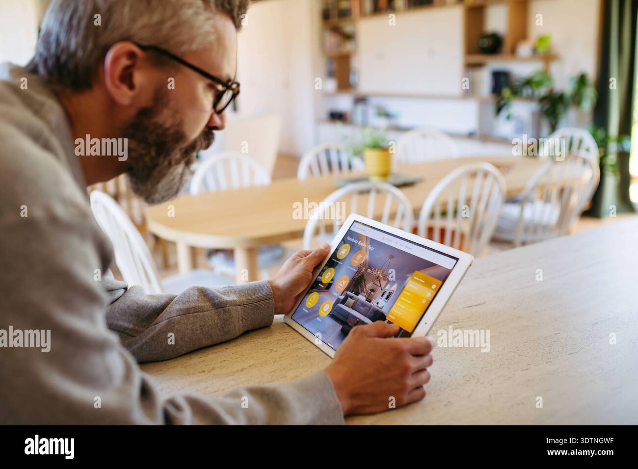 Man using smart home control panel. Man using smart home control panel, adjusting temperature. model released Stock Photo