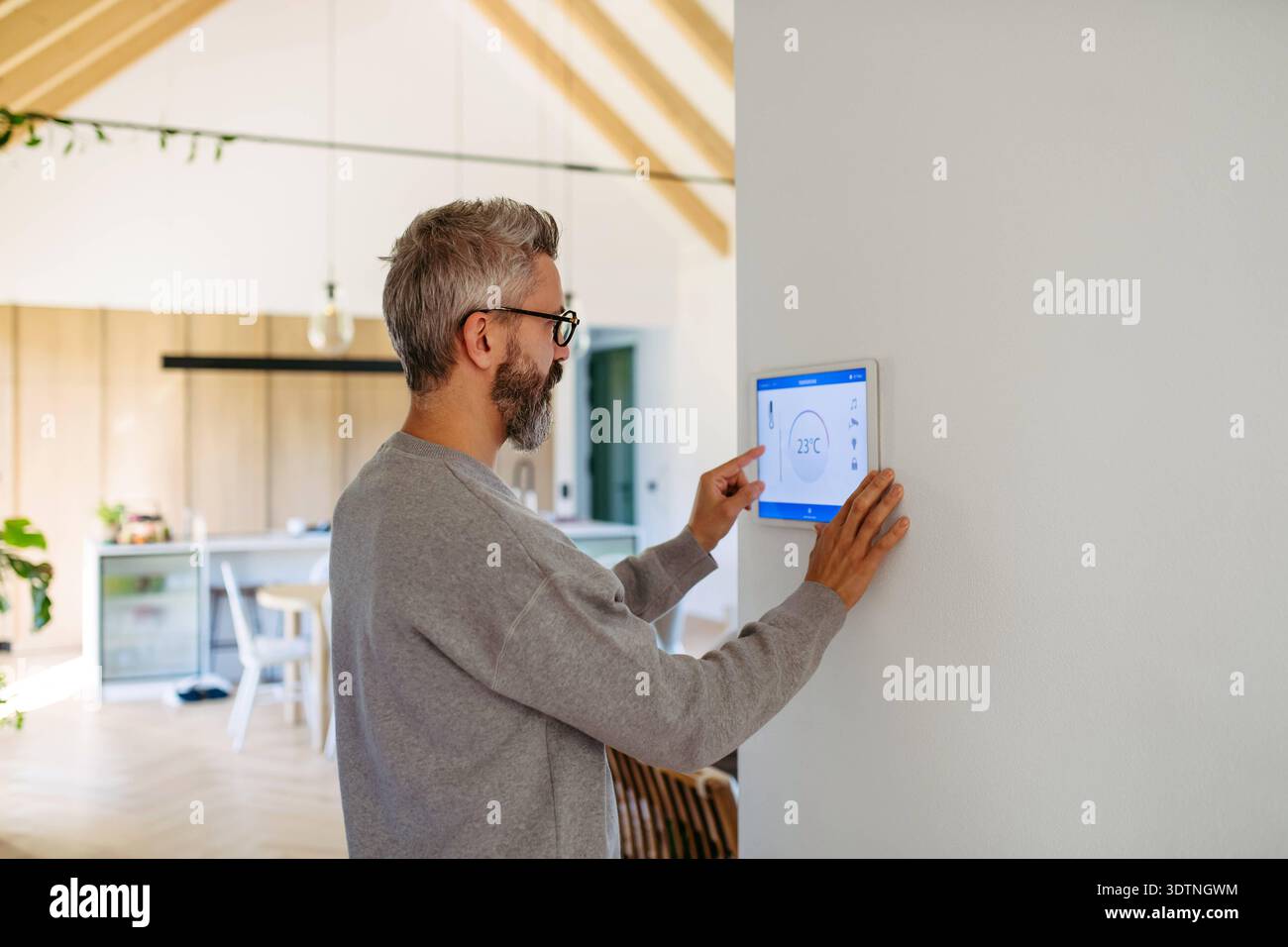 Man using smart home control panel. Man using smart home control panel, adjusting temperature. model released Stock Photo
