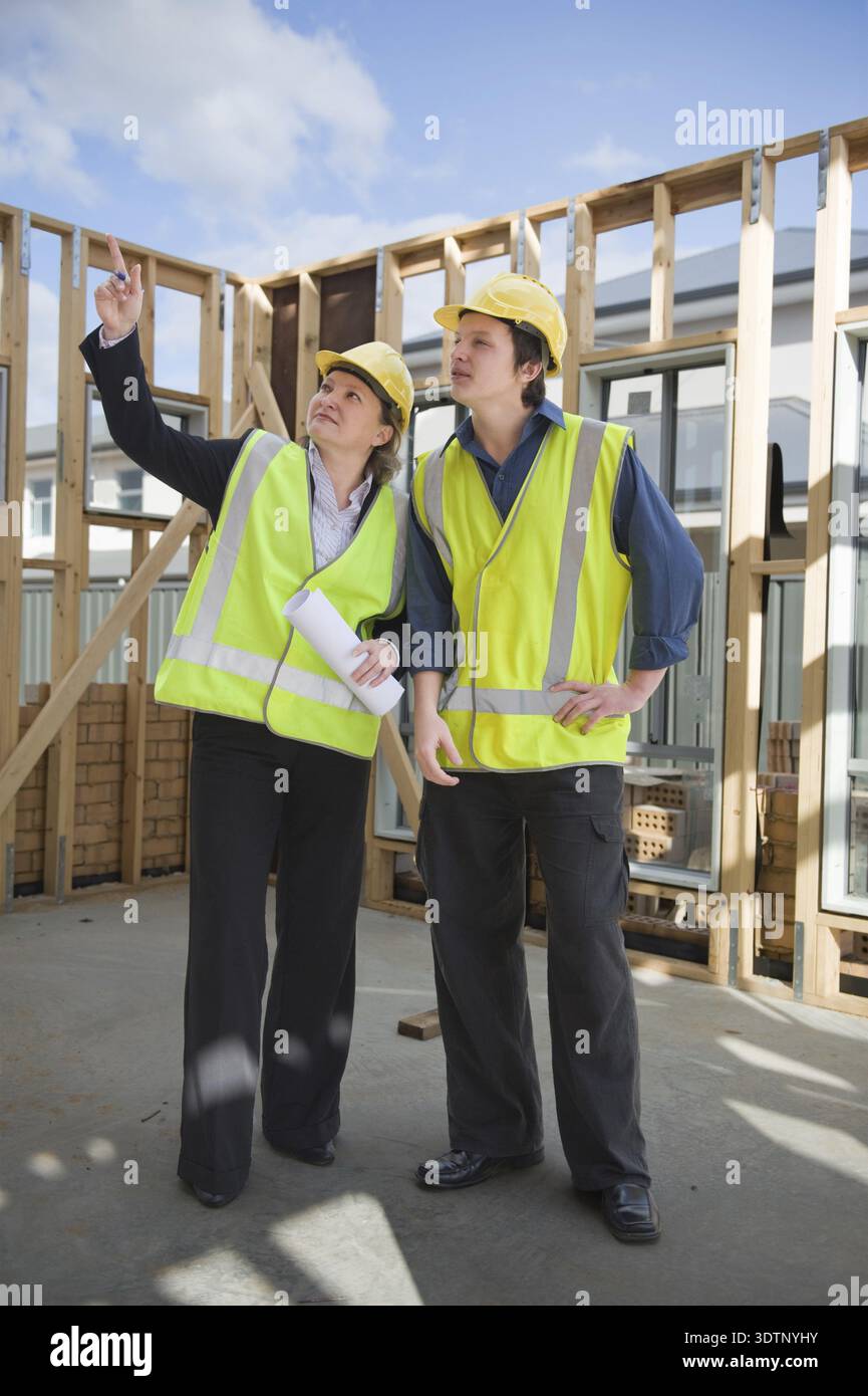 Civil engineer and worker discussing issues at the construction site Stock Photo