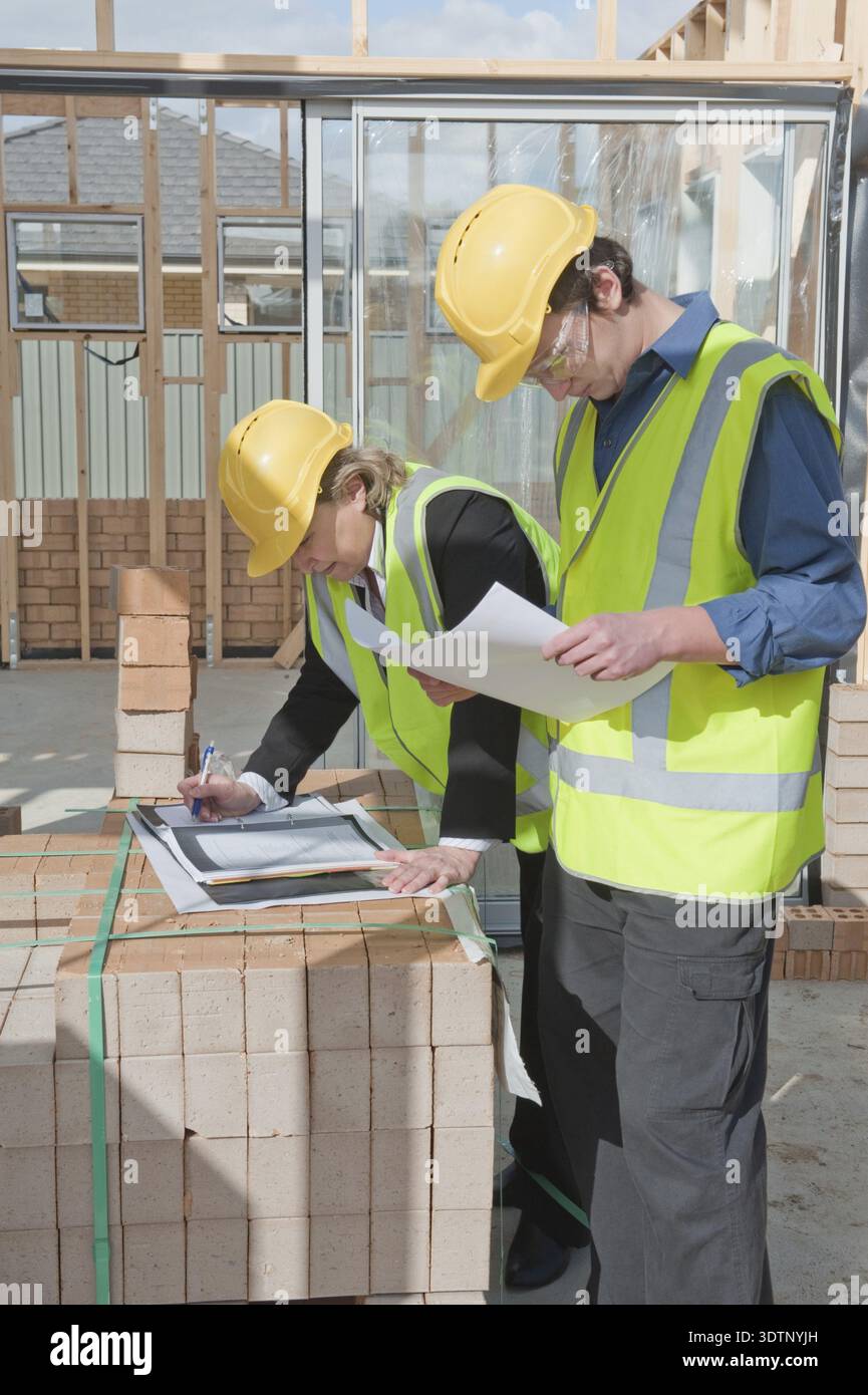 Civil engineer and worker discussing issues at the construction site Stock Photo