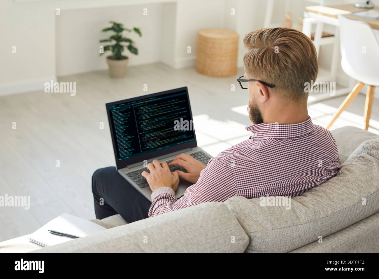 Man coding on laptop at home office, remote software developer working online Stock Photo