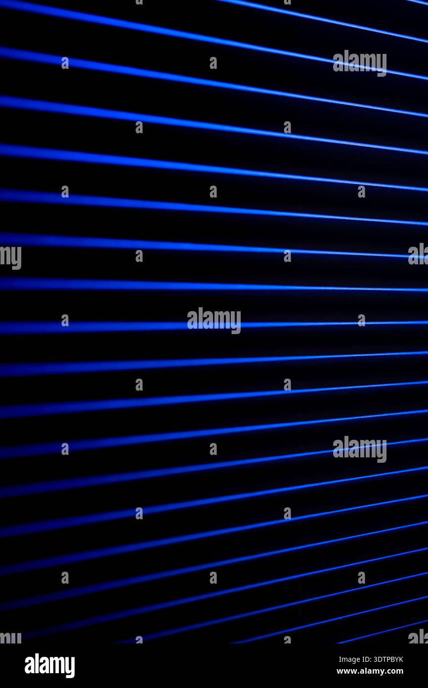 Vertical neon pattern of blue lines. Dark background. Stock Photo