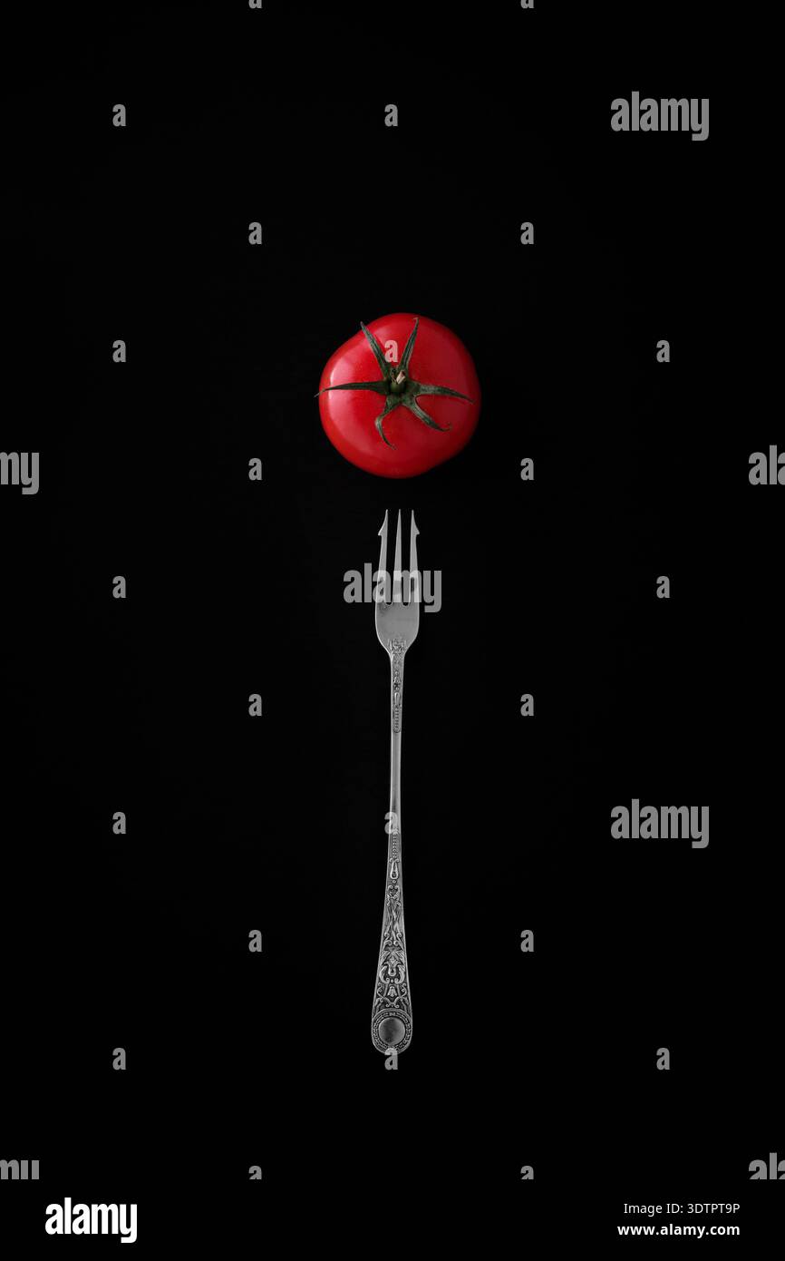 A tomato and silver fork. Stock Photo