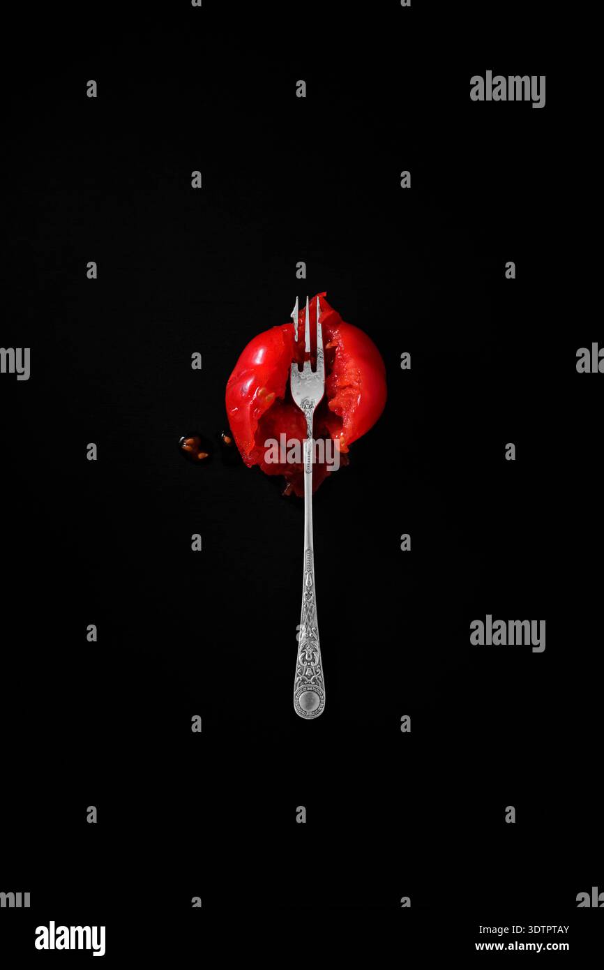 A squashed tomato and silver fork. Stock Photo
