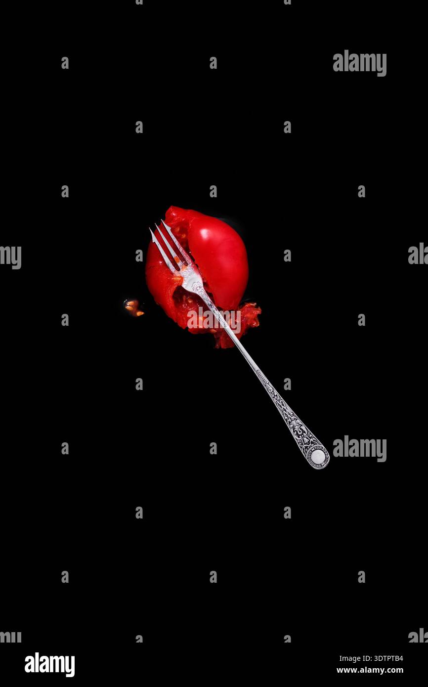 A squashed tomato and silver fork. Stock Photo