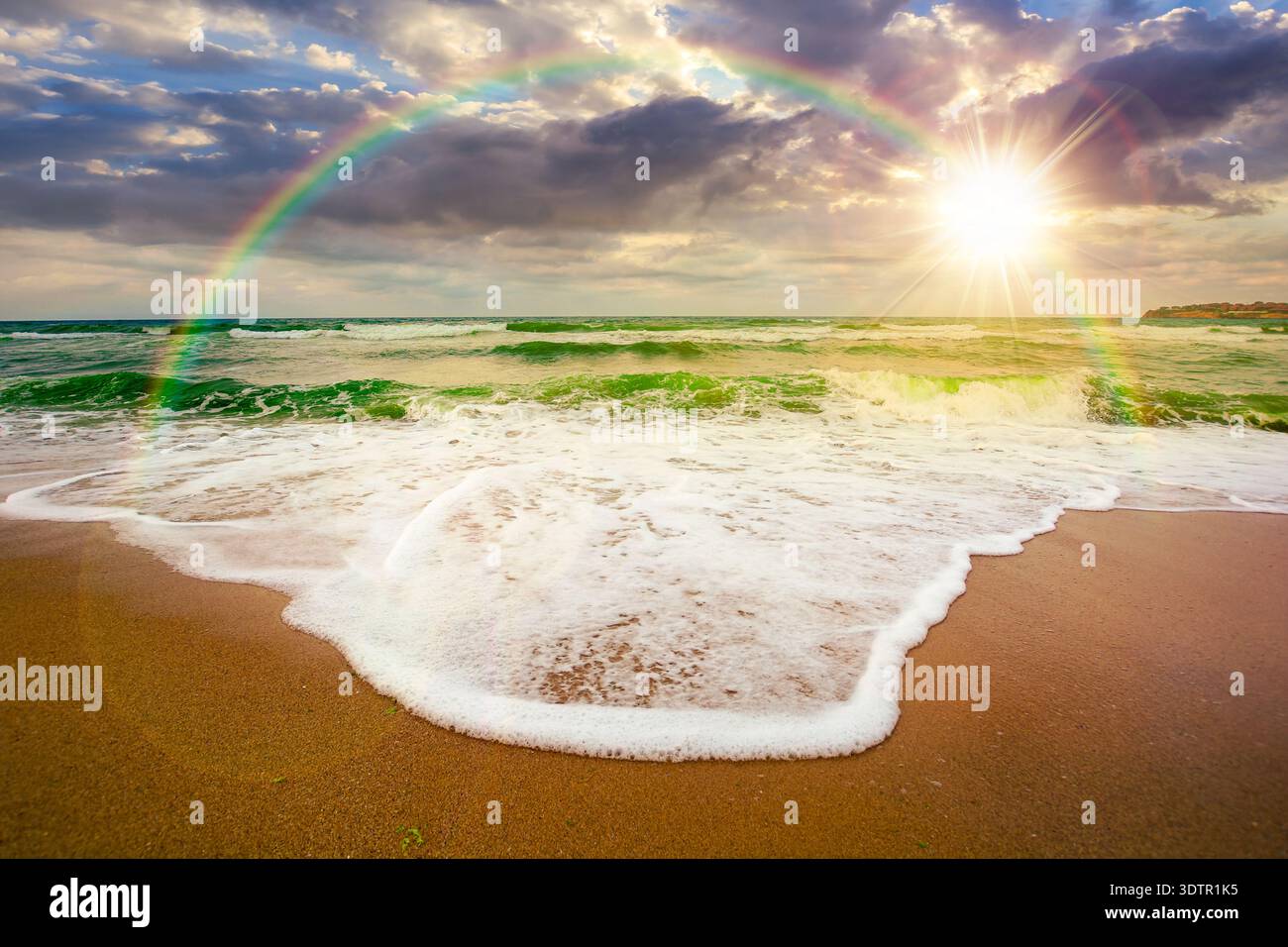 sunset over tide rolling on the sandy beach. sea waves beneath a cloudy sky. empty calm scenery in summer. loneliness concept. generic image for wallp Stock Photo