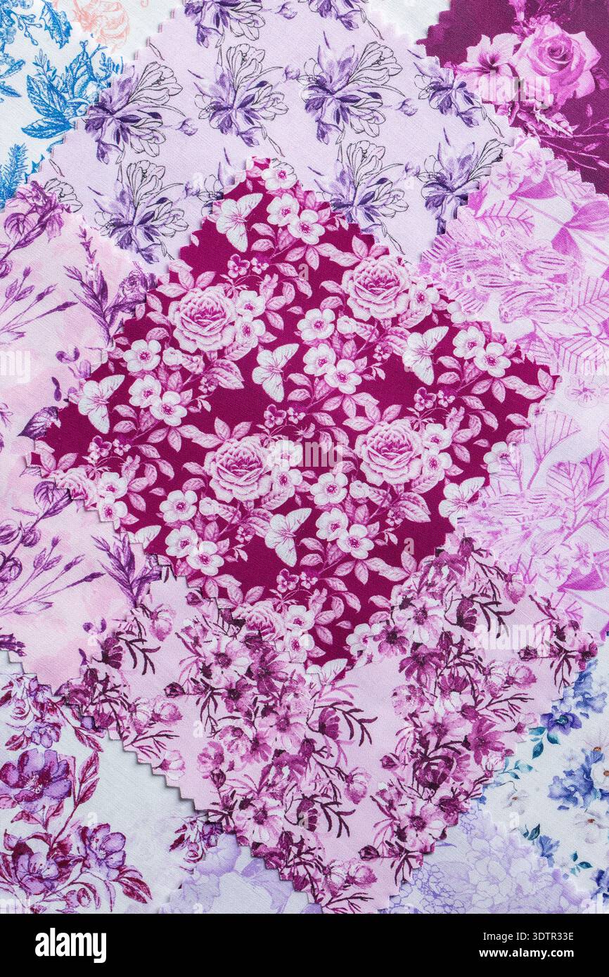 Fabric patchwork squares, in various colours and designs, stacked background backdrop. Sewing craft needlework concept. Stock Photo