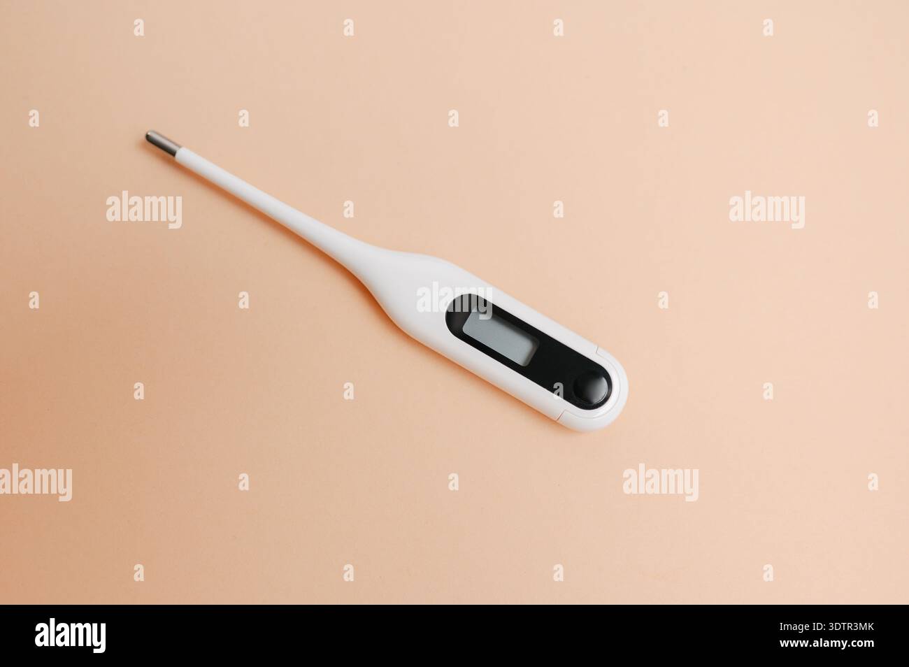 Minimalist White Digital Thermometer Featuring Metal Tip Against Peach Background For Health Checks Stock Photo
