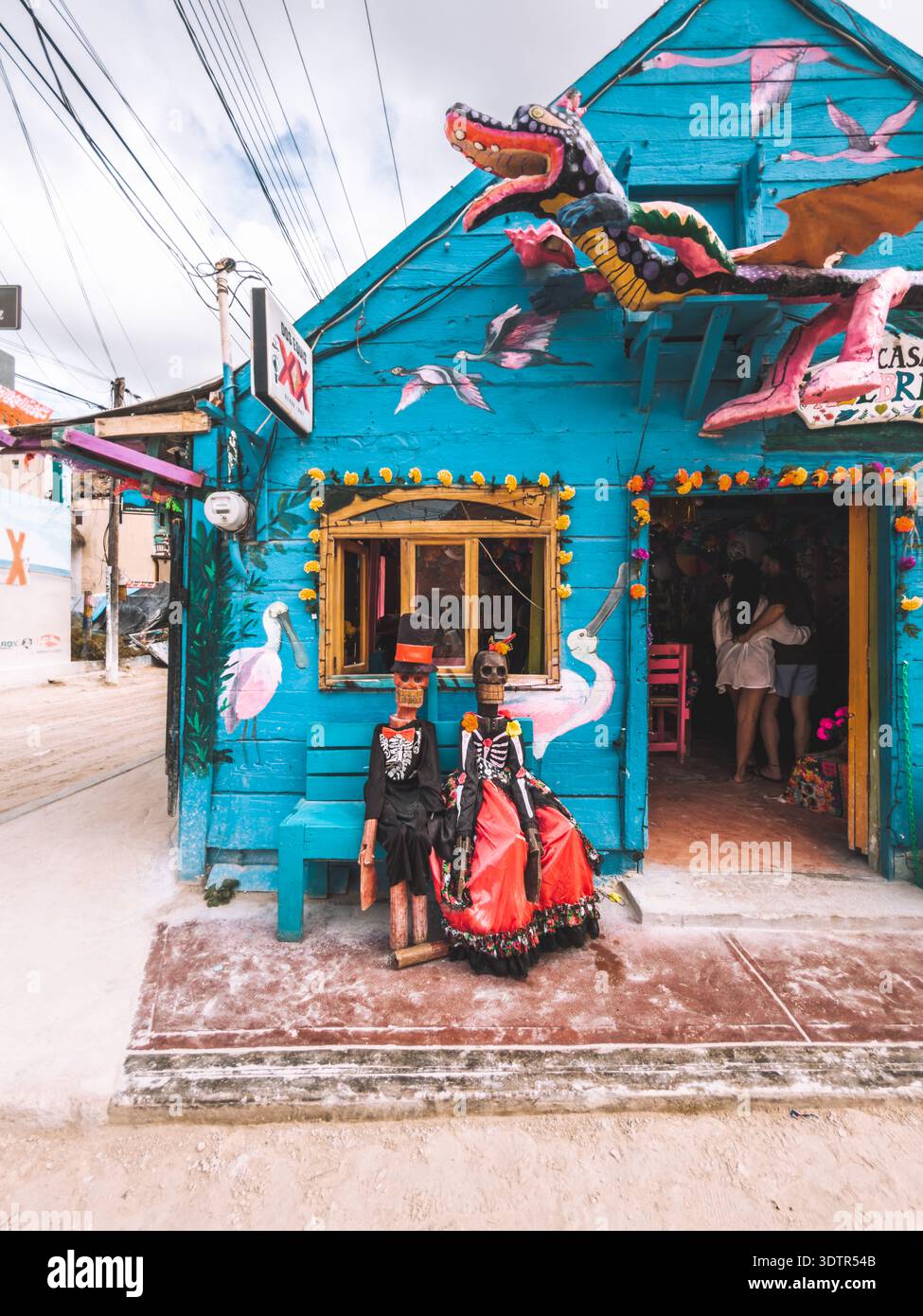 Colorful wooden shop with dragon sculpture and Day of the Dead skeleton figures in Holbox, Mexico. Stock Photo