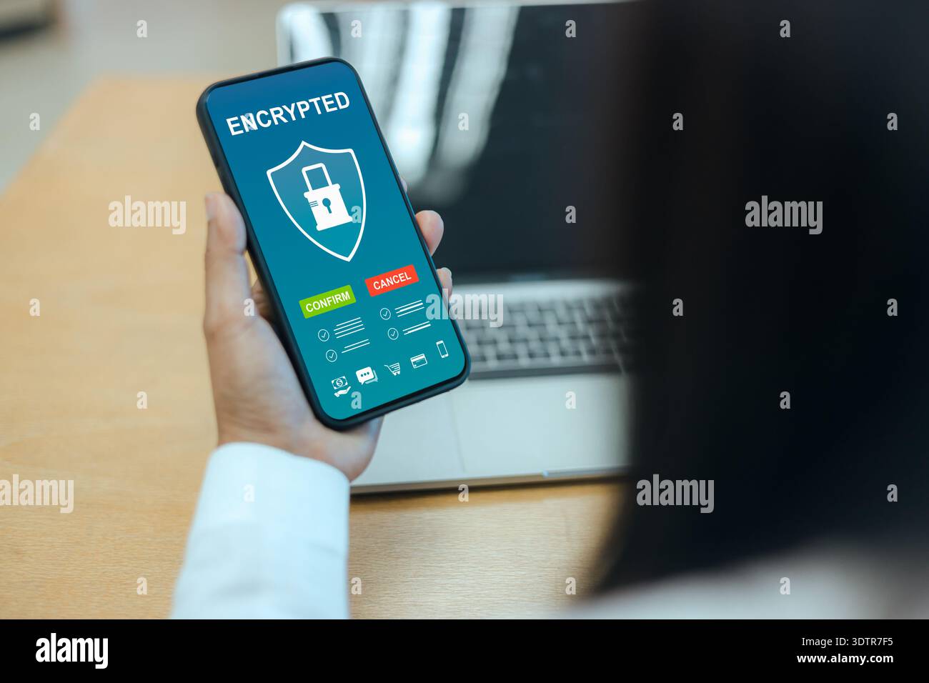 Close up of a person holding a smartphone with an encrypted security interface, featuring shield and lock icons for mobile data protection and digital Stock Photo