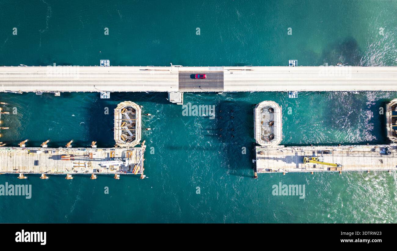 Red Drawbridge Aerial view of a drawbridge over the ocean, with a lone red car ...