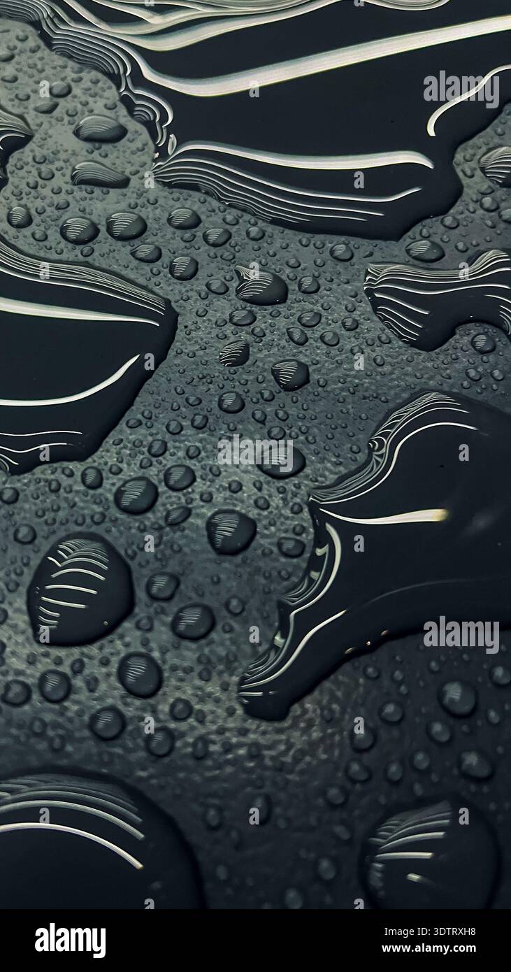 An Abstract Exploration of Water Droplets on a Dark Textured Surface Capturing Fluidity and Reflection Dynamics Stock Photo