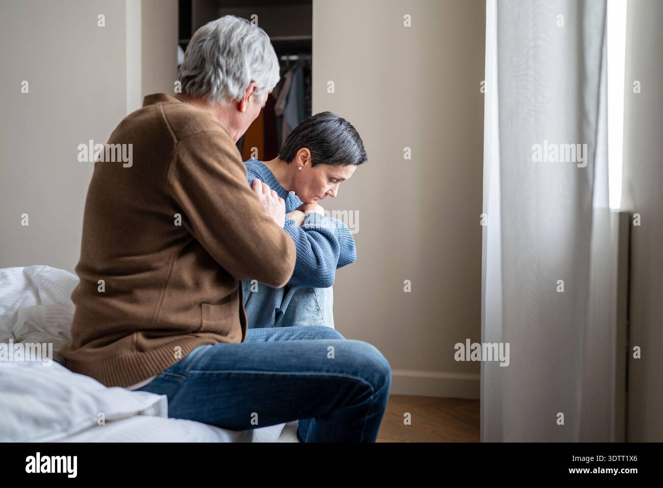 Toxic relationships and manipulations, narcissistic husband calming down mentally exhausted wife. Stock Photo