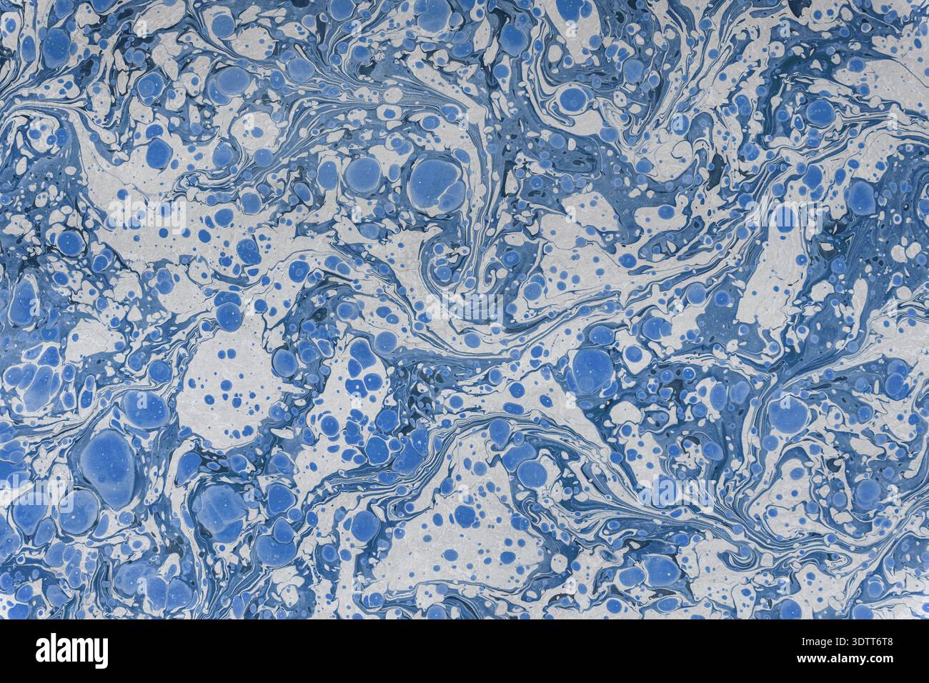Blue and white marbling paper creating an abstract swirled texture Stock Photo
