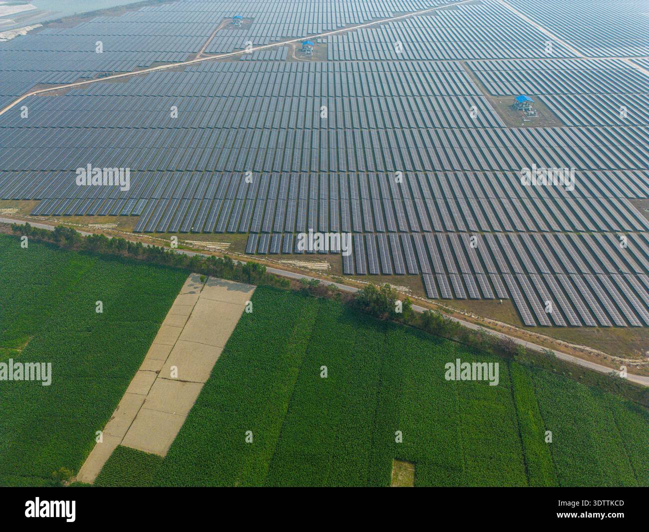 Solar Array Fields Aerial view of vast solar panel array contrasting with the vivid green ...