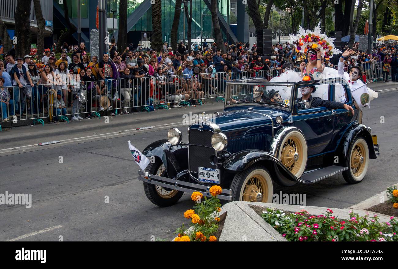People in costumes parade in a vintage Ford Model A during the Day of the Dead celebration in Mexico City, Mexico Stock Photo