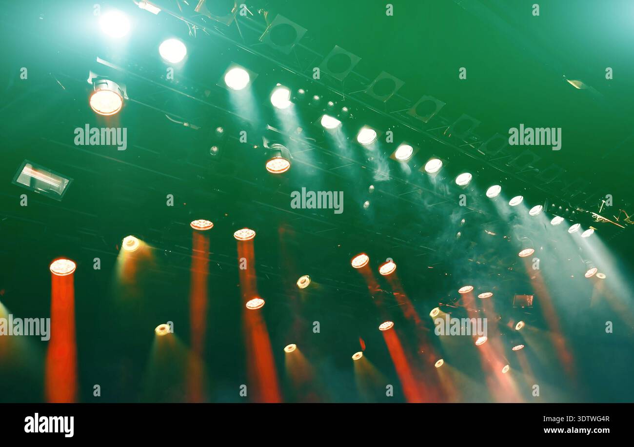 glowing ceiling green spotlights working during the musical concert, lights the stage Stock Photo