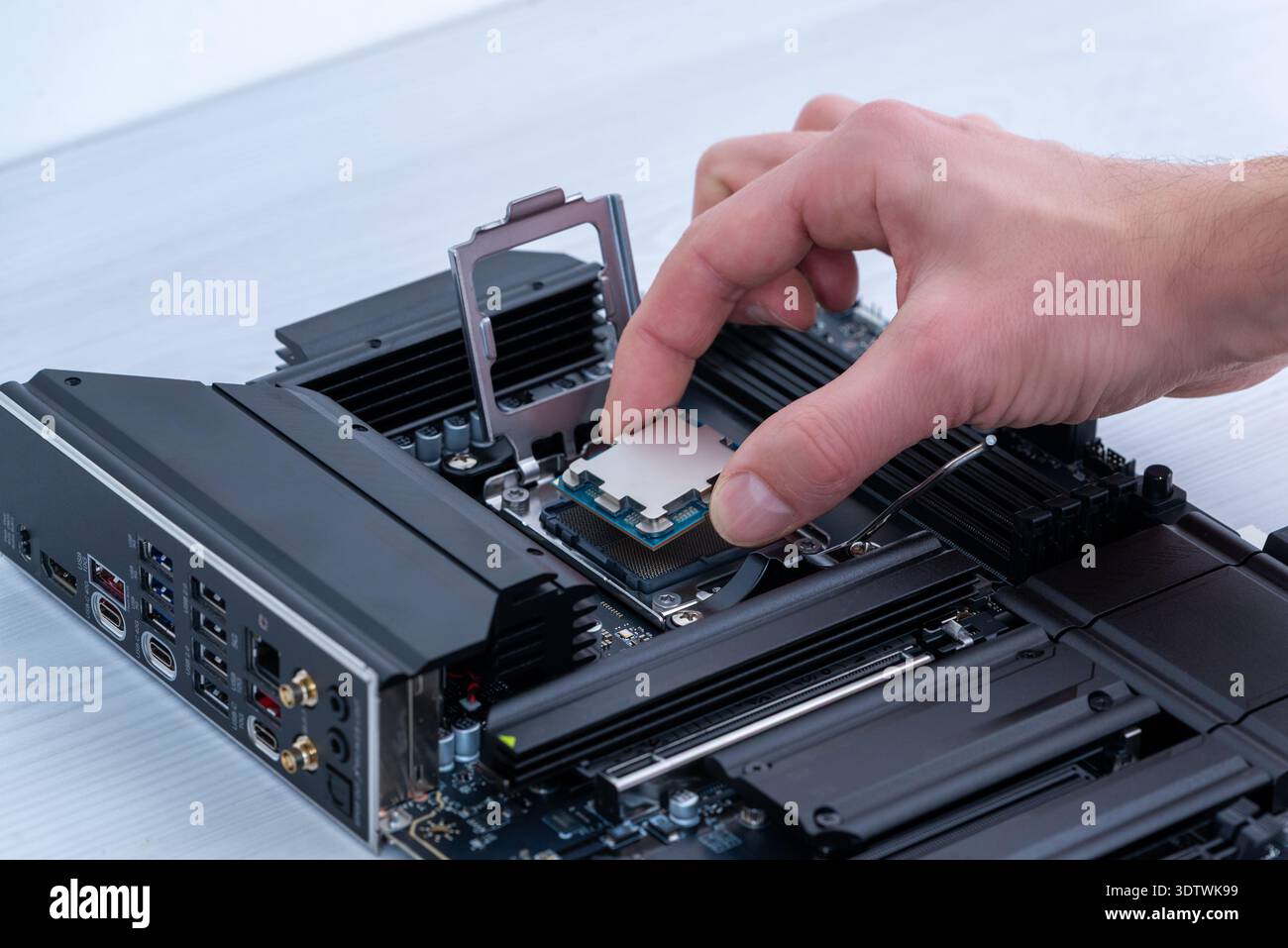 Hand installing desktop processor into motherboard socket, computer assembly process and high performance pc building concept Stock Photo