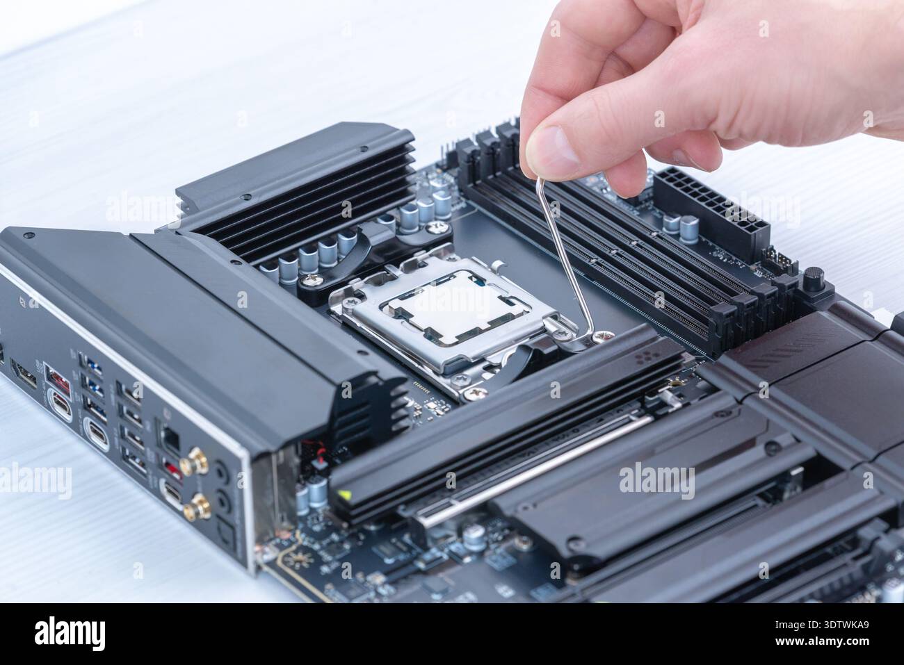 Securing cpu in motherboard socket with retention bracket, detailed computer hardware installation and pc assembly process Stock Photo