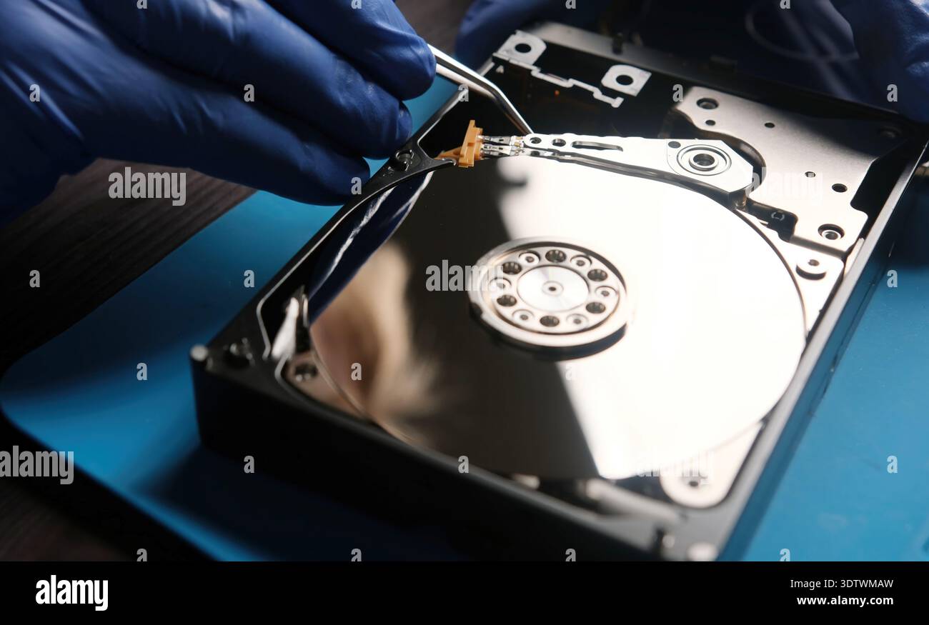 Serviceman repairs hdd data disk in service center Stock Photo