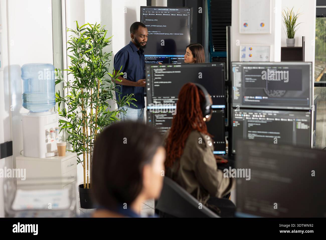 Professional team of developers conducting software code review in open workspace. Group collaboration focused on programming, data analysis and technical strategy in modern office. Stock Photo