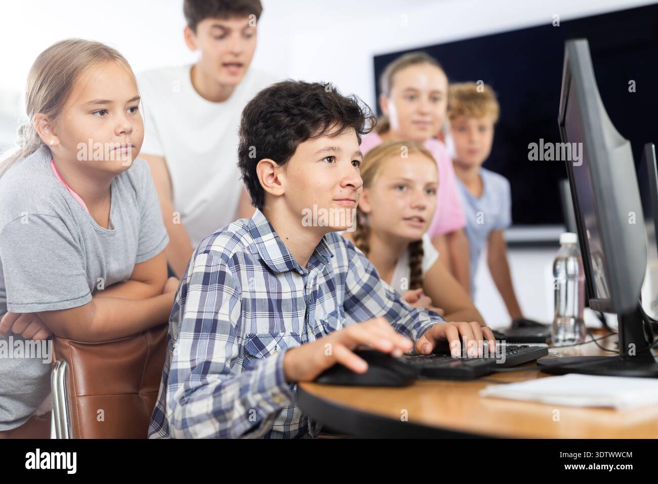 Classmates solve computer problem together in school computer class ...
