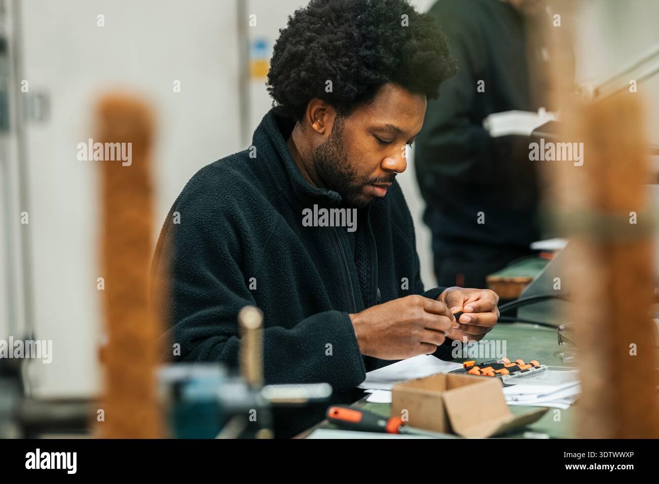 Concentrated male worker working on mechanics in factory Stock Photo