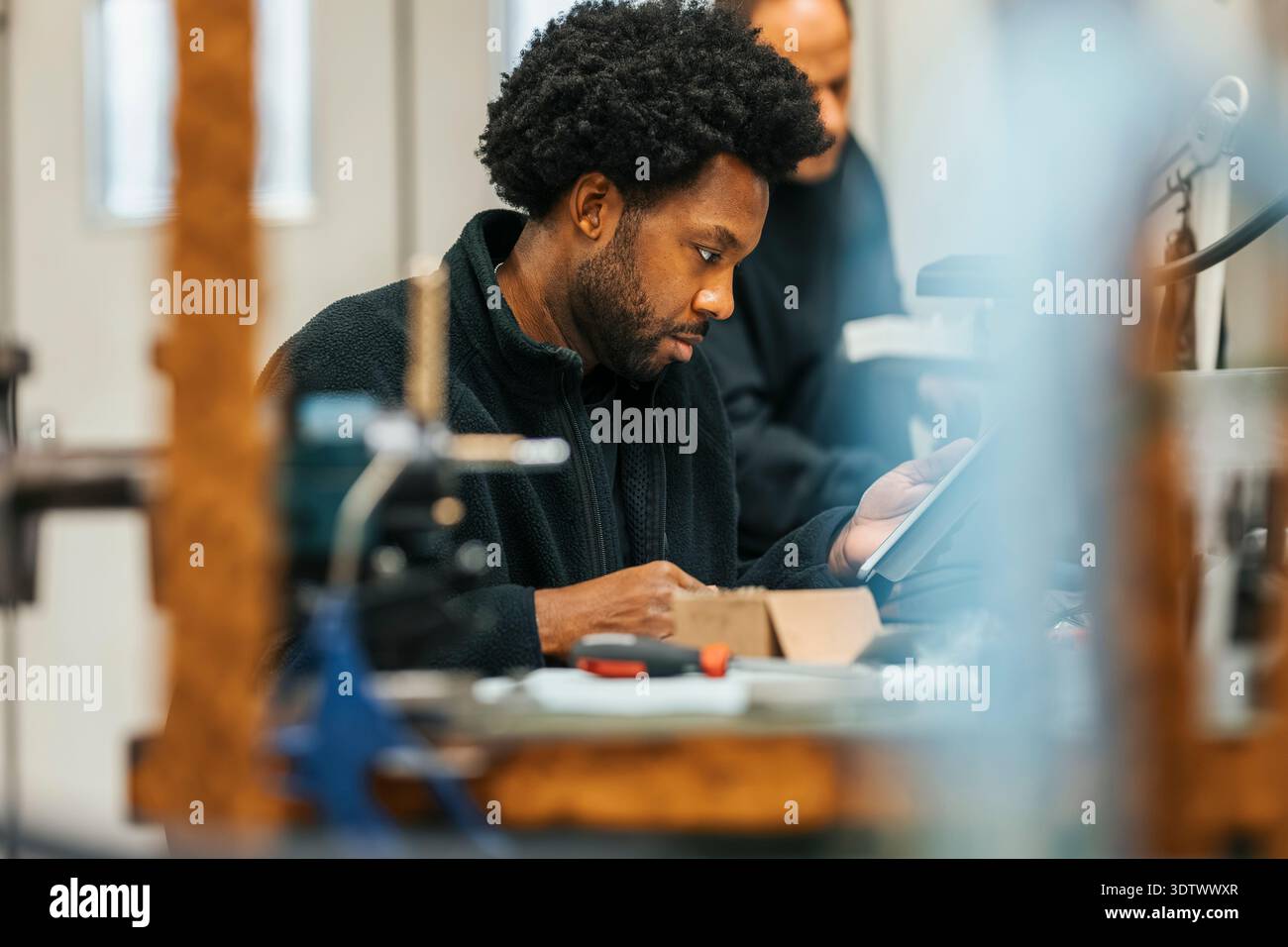 Focused male worker using tablet PC while working in factory Stock Photo