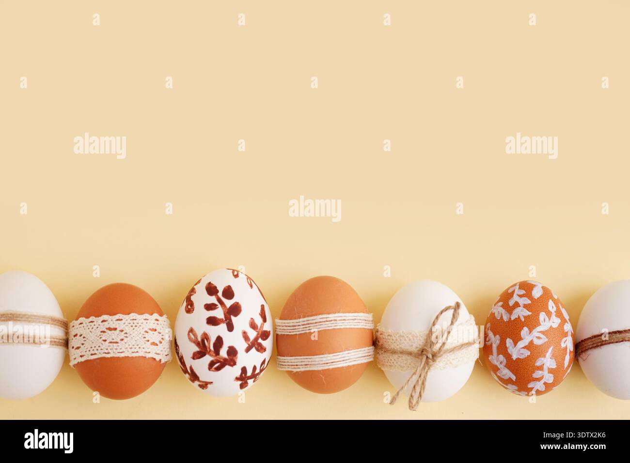 Composition with decorated Easter eggs on beige background Stock Photo