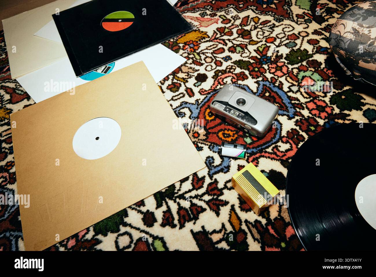 Film camera with old vinyl records on patterned carpet Stock Photo