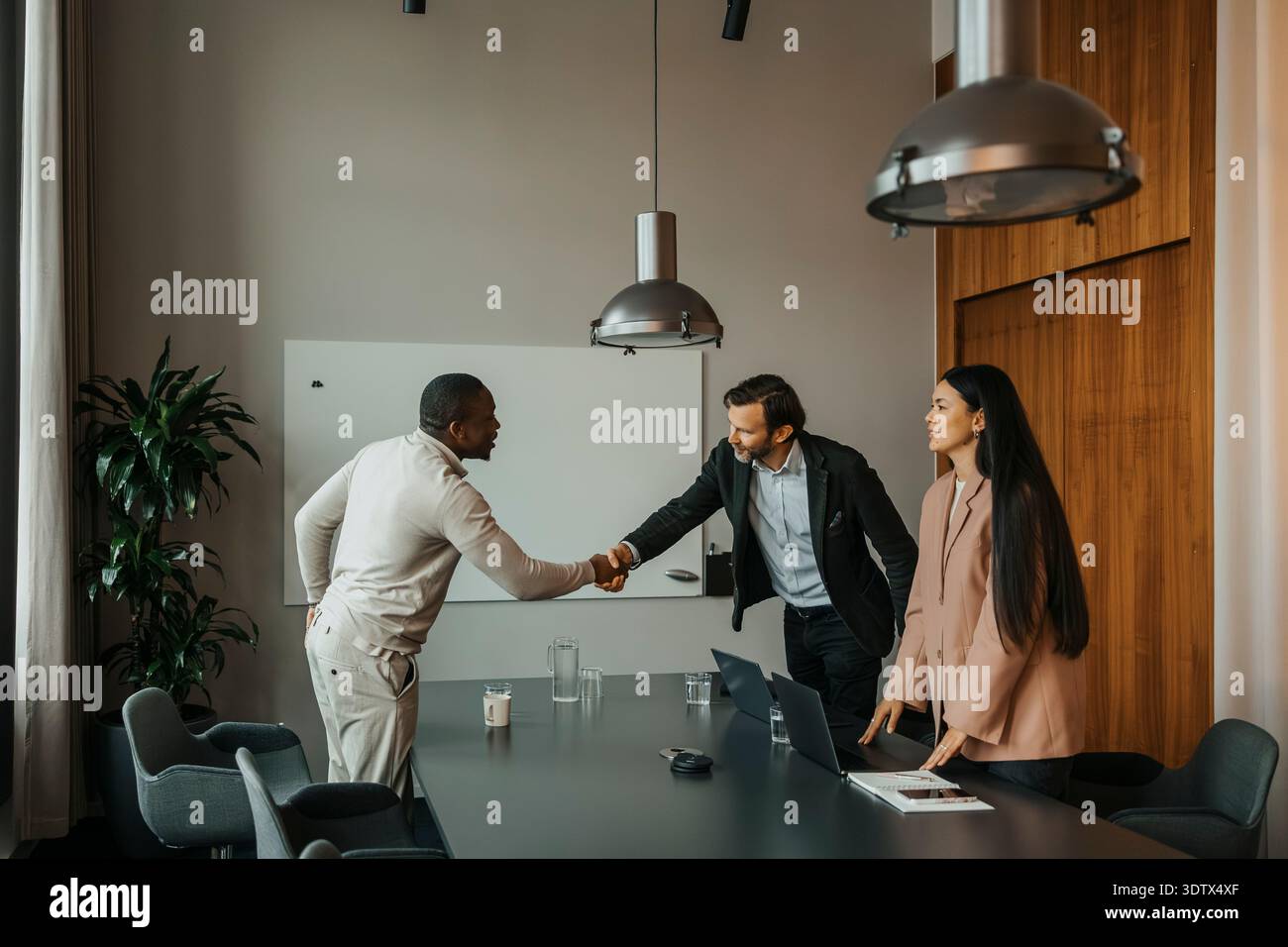 Male manager doing handshake with candidate after interview at office Stock Photo