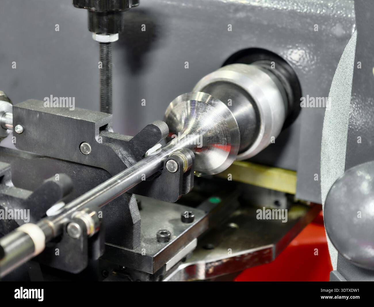 Precision valve grinding machine refacing a valve component in a mechanical workshop Stock Photo