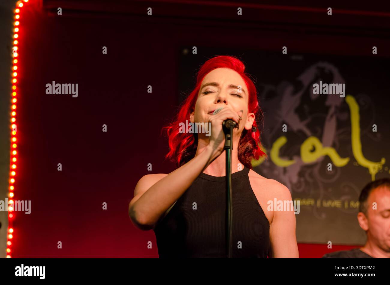 Stop Sign Singer Female singer with red hair passionately singing into a microphone on ...