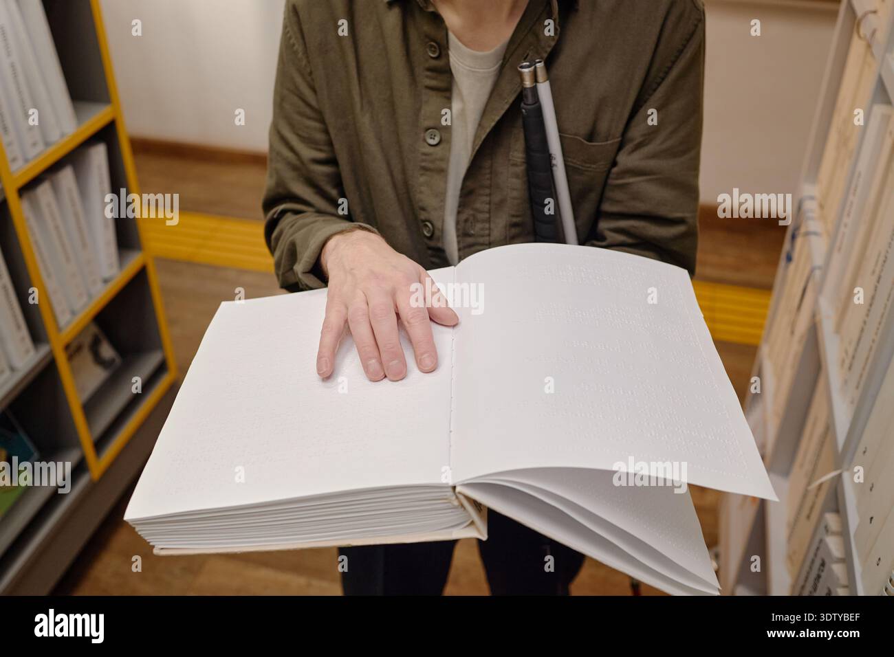 Middle Aged Man Reading Braille Book in Library While Standing Stock Photo